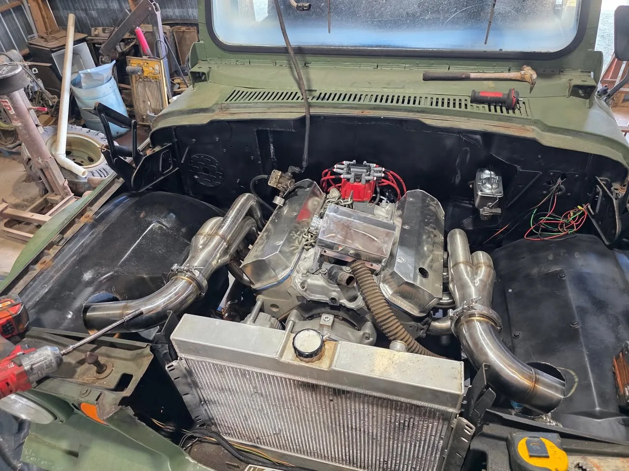 V8 engine with polished valve covers, red distributor and stainless headers installed in Sarge's engine bay